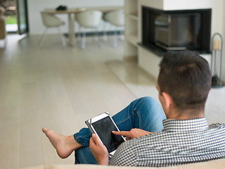 Image showing man on sofa using tablet computer