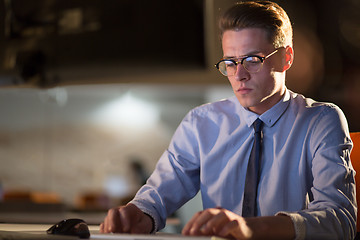 Image showing man working on computer in dark office