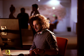 Image showing man working on computer in dark office