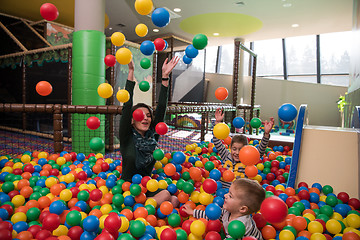 Image showing Young mom with her kids in a children\'s playroom