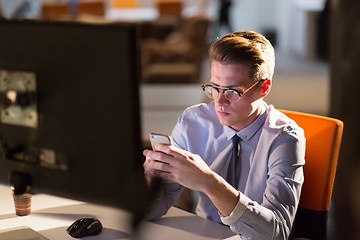 Image showing man using mobile phone in dark office