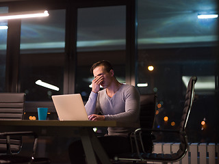 Image showing man working on laptop in dark office