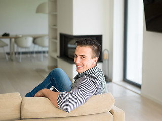 Image showing man on sofa using tablet computer