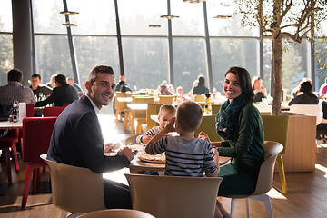 Image showing Young parents enjoying lunch time with their children