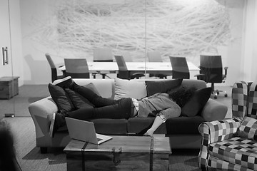 Image showing man sleeping on a sofa  in a creative office