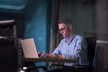 Image showing man working on laptop in dark office