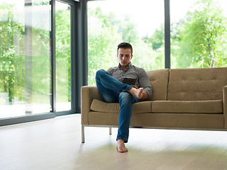 Image showing man on sofa using tablet computer