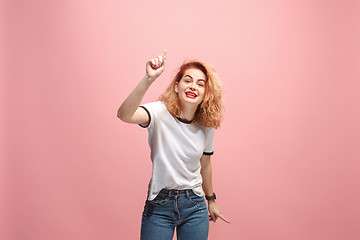 Image showing Beautiful female half-length portrait isolated on pink studio backgroud. The young emotional surprised woman