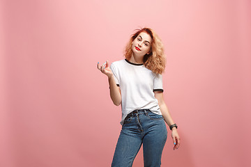 Image showing Beautiful female half-length portrait isolated on pink studio backgroud. The young emotional surprised woman