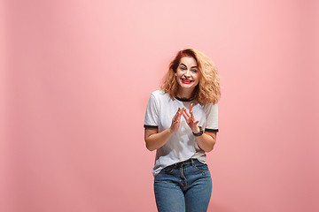 Image showing The happy business woman standing and smiling against pink background.