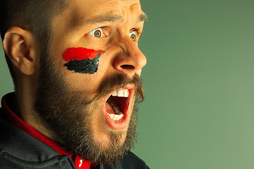 Image showing Portrait of a man with the flag of the Germany painted on him face.