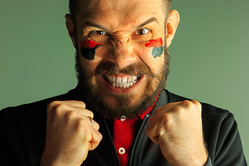 Image showing Portrait of a man with the flag of the Germany painted on him face.