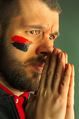 Image showing Portrait of a man with the flag of the Germany painted on him face.