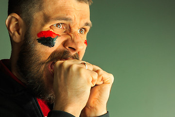 Image showing Portrait of a man with the flag of the Germany painted on him face.