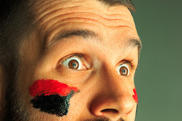 Image showing Portrait of a man with the flag of the Germany painted on him face.