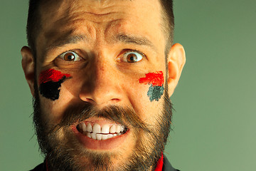 Image showing Portrait of a man with the flag of the Germany painted on him face.