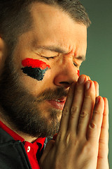 Image showing Portrait of a man with the flag of the Germany painted on him face.