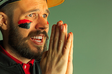 Image showing Portrait of a man with the flag of the Germany painted on him face.