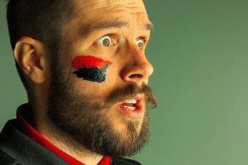 Image showing Portrait of a man with the flag of the Germany painted on him face.