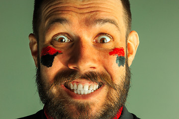 Image showing Portrait of a man with the flag of the Germany painted on him face.