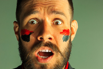 Image showing Portrait of a man with the flag of the Germany painted on him face.