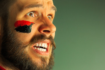 Image showing Portrait of a man with the flag of the Germany painted on him face.