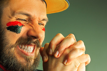 Image showing Portrait of a man with the flag of the Germany painted on him face.