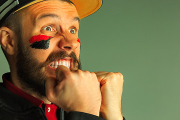 Image showing Portrait of a man with the flag of the Germany painted on him face.