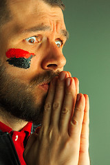 Image showing Portrait of a man with the flag of the Germany painted on him face.