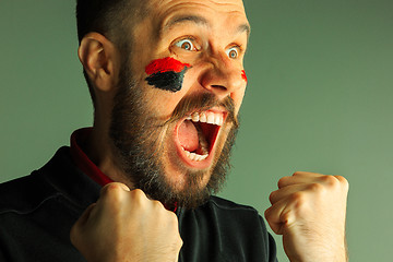 Image showing Portrait of a man with the flag of the Germany painted on him face.