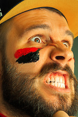 Image showing Portrait of a man with the flag of the Germany painted on him face.