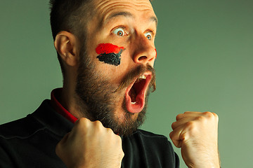 Image showing Portrait of a man with the flag of the Germany painted on him face.