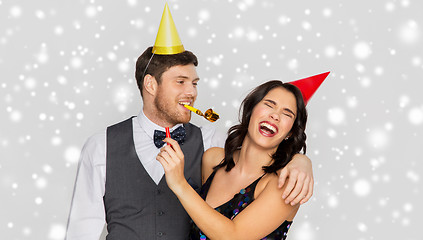 Image showing happy couple with party blowers having fun