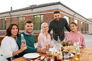 Image showing happy friends with drinks or bbq party on rooftop