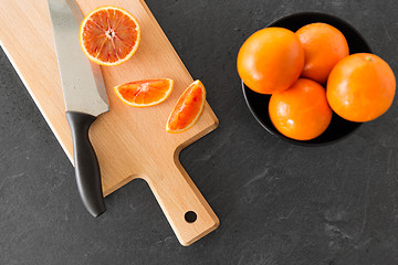 Image showing close up of oranges and knife on cutting board