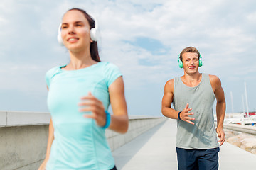 Image showing couple with headphones running outdoors