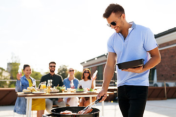 Image showing man cooking meat on bbq at rooftop party