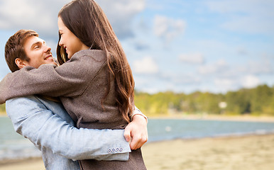 Image showing happy young couple hugging over autumn beach