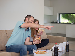 Image showing couple eating pizza in their luxury home villa