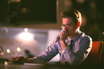 Image showing man working on computer in dark office