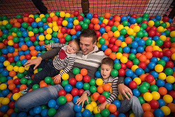 Image showing Young dad with kids in a children\'s playroom