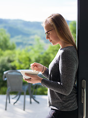 Image showing woman eating breakfast in front of her luxury home villa