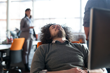 Image showing young businessman relaxing at the desk