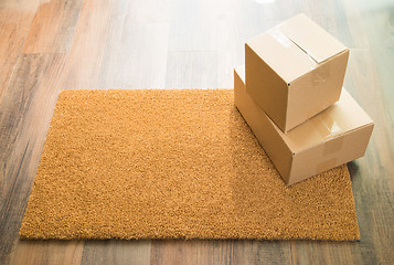 Image showing Blank Welcome Mat On Wood Floor With Shipment of Boxes