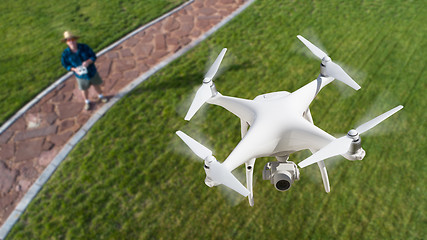 Image showing Drone Quadcopter (UAV) In Air Above Pilot With Remote Controller