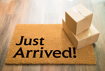 Image showing Just Arrived Welcome Mat On Wood Floor With Shipment of Boxes