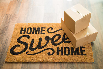 Image showing Home Sweet Home Welcome Mat On Wood Floor With Boxes