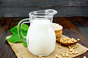 Image showing Milk soy in jug with flour on dark board