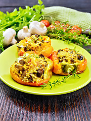 Image showing Pepper stuffed with mushrooms and couscous in green plate on woo