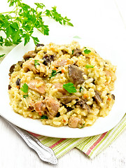 Image showing Risotto with mushrooms and chicken on wooden table